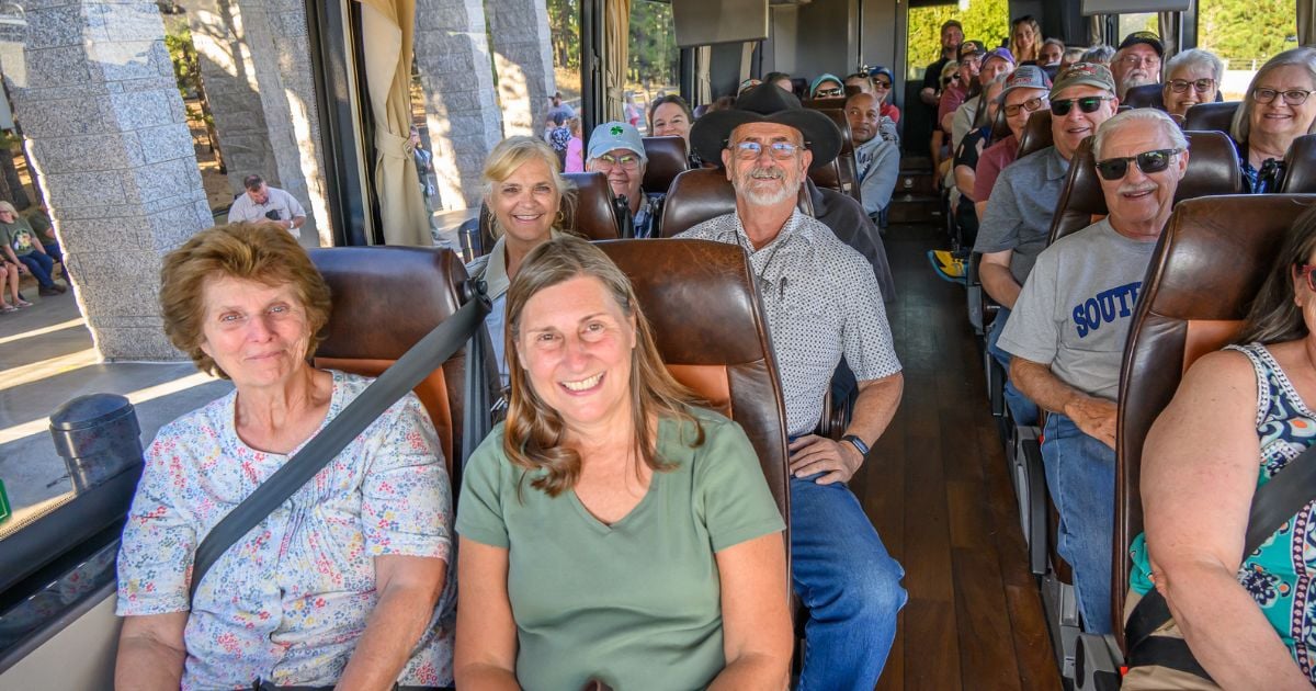 Tour guests smiling with their guide at a Mount Rushmore National Monument